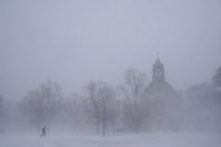 Một người đi bộ đơn độc trên đôi giày đi tuyết băng qua Colonial Circle khi Nhà thờ St. John's Grace Episcopal hiện ra giữa cơn bão tuyết ở Buffalo, New York hôm 24/12/2022. (Ảnh: Derek Gee/The Buffalo News via AP)
