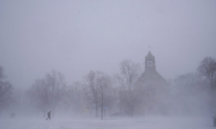 Một người đi bộ đơn độc trên đôi giày đi tuyết băng qua Colonial Circle khi Nhà thờ St. John's Grace Episcopal hiện ra giữa cơn bão tuyết ở Buffalo, New York hôm 24/12/2022. (Ảnh: Derek Gee/The Buffalo News via AP)