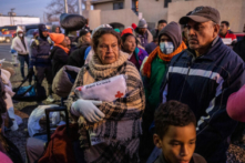 Những người nhập cư bất hợp pháp chờ để vào nơi trú ẩn tại Nhà thờ Thánh Tâm ở El Paso, Texas, hôm 17/12/2022. (Ảnh: John Moore/Getty Images)