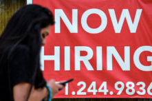Một người phụ nữ đi ngang qua tấm biển ‘Đang tuyển dụng’ bên ngoài một cửa hàng ở Arlington, Virginia, vào ngày 16/08/2021. (Ảnh: Olivier Douliery/AFP via Getty Images)