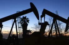 Một máy bơm dầu (Trái) hoạt động trong khi một máy bơm dầu khác (Phải) đứng yên trong mỏ dầu Inglewood ở Los Angeles, California, hôm 28/11/2022. (Ảnh: Mario Tama/Getty Images)
