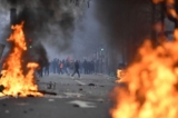 Những người phản đối đứng phía sau các đám cháy trong các cuộc đụng độ sau một cuộc biểu tình của các thành viên trong cộng đồng người Kurd, một ngày sau khi một người đàn ông nổ súng tại một trung tâm văn hóa của người Kurd khiến ba người thiệt mạng, tại Quảng trường Cộng Hòa ở Paris hôm 24/12/2022. (Ảnh: Julien de Rosa/AFP qua Getty Images)