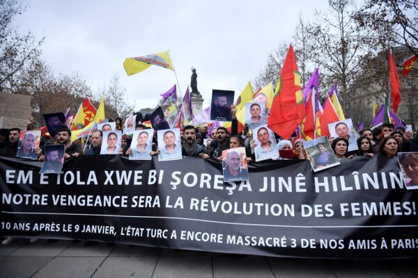 Người biểu tình cầm cờ của Đảng Công nhân người Kurd (PKK) và chân dung các nạn nhân trong một cuộc biểu tình của những người ủng hộ và các thành viên của cộng đồng người Kurd, một ngày sau khi một người đàn ông nổ súng tại một trung tâm văn hóa của người Kurd, khiến ba người thiệt mạng, tại Quảng trường Cộng Hòa ở Paris hôm 24/12/2022. (Ảnh: Julien de Rosa/AFP qua Getty Images)