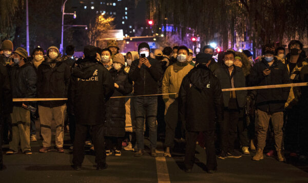 Công an giữ một số người biểu tình sau một hàng rào trong cuộc biểu tình phản đối các biện pháp zero COVID nghiêm ngặt của chính quyền Trung Quốc tại Bắc Kinh, Trung Quốc, hôm 27/11/2022. (Ảnh: Kevin Frayer/Getty Images)
