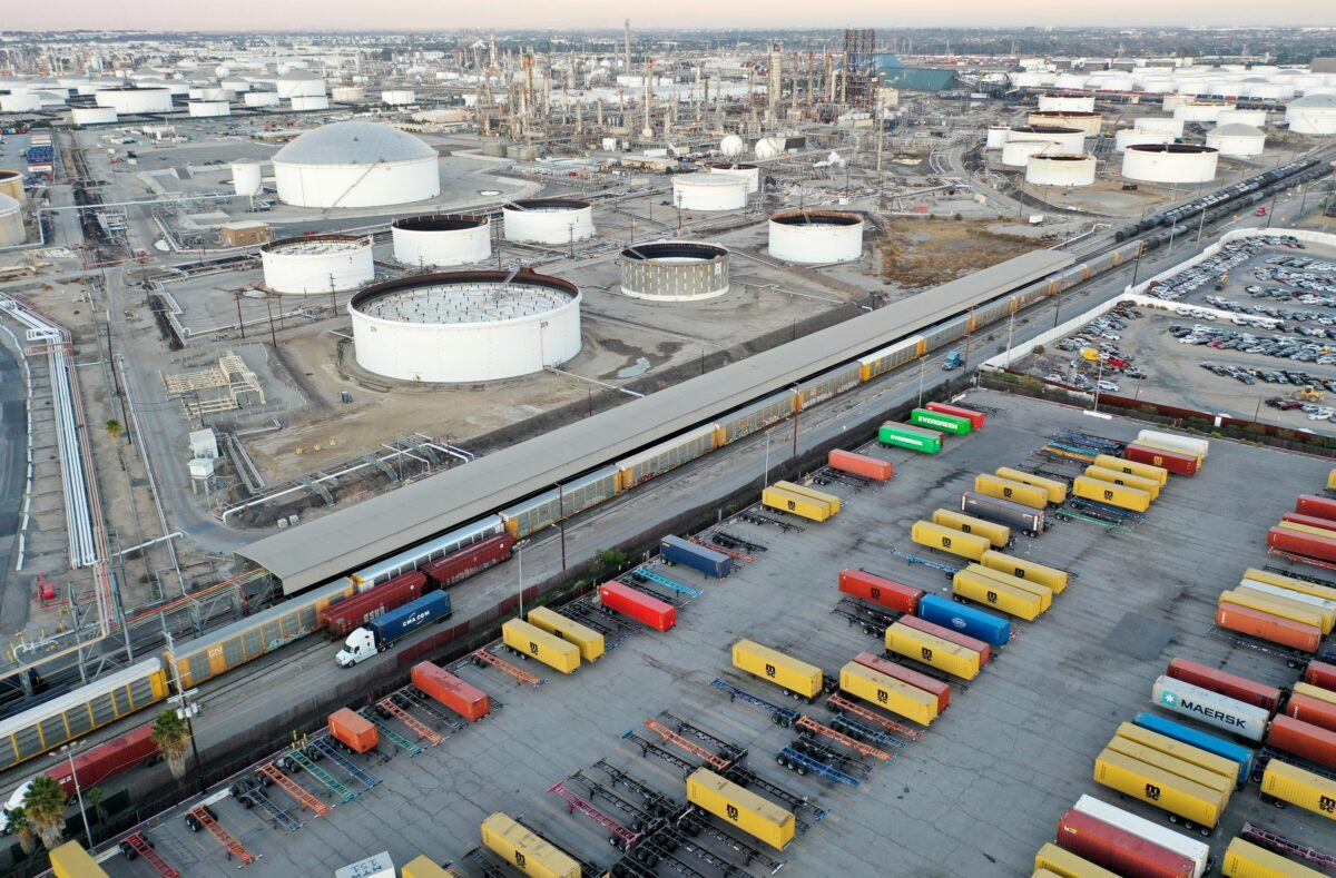 Một toa tàu chở hàng (giữa) băng qua các container hàng ở Wilmington, tiểu bang California, hôm 22/11/2022. (Ảnh: Mario Tama/Getty Images)