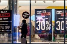 Một người phụ nữ đi ngang qua các biển quảng cáo giảm giá Black Friday ở quận Manhattan của Thành phố New York, New York, hôm 26/11/2021. (Ảnh: Jeenah Moon/Reuters)