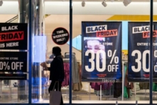 Một người phụ nữ đi ngang qua các biển quảng cáo giảm giá Black Friday ở quận Manhattan của Thành phố New York, New York, hôm 26/11/2021. (Ảnh: Jeenah Moon/Reuters)