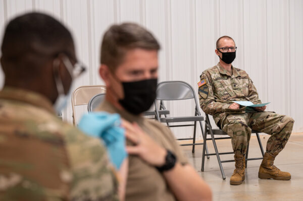 Một người lính đứng nhìn một người lính khác được chích vaccine COVID-19 ở Fort Knox, Kentucky, vào ngày 09/09/2021. (Ảnh: Jon Cherry/Getty Images)