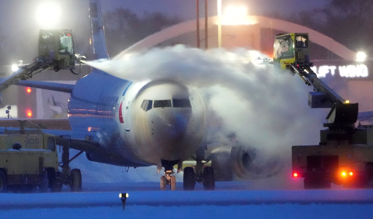 Một chiếc phi cơ của American Airlines được làm tan băng bằng luồng khí công suất lớn thổi bay lớp tuyết dày 7.5 inch (gần 20cm) tại Phi trường Quốc tế Minneapolis-St. Paul, hôm 22/12/2022. (Ảnh: David Joles/Star Tribune qua AP)