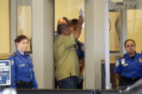 Một khách du lịch bước vào khu vực kiểm tra an ninh khi các nhân viên của Cơ quan Quản lý An ninh Giao thông kiểm tra tại Phi trường Quốc tế Los Angeles vào tháng 11/2013. (Ảnh: Kevork Djansezian/Getty Images)