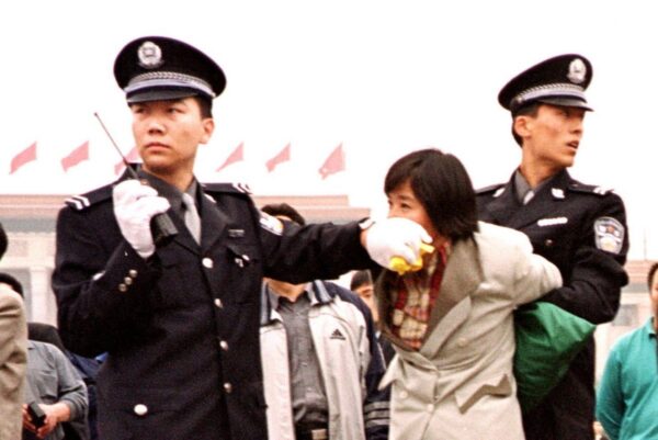 Hai cảnh viên Trung Quốc bắt giữ một học viên Pháp Luân Công tại Quảng trường Thiên An Môn ở Bắc Kinh vào ngày 10/01/2000. (Ảnh: Chien-Min Chung/AP Photo)