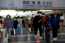 Du khách mang theo hành lý đi bộ tại Phi trường Quốc tế Thủ đô Bắc Kinh ở Bắc Kinh, hôm 27/12/2022. (Ảnh: Tingshu Wang/Reuters)