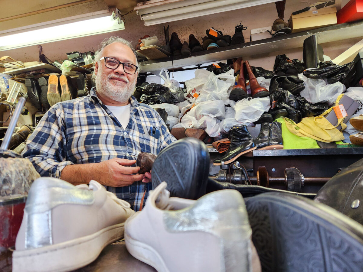 Người thợ sửa giày Felipe Torres đang sửa một đôi giày da cũ bên trong căn tiệm hình chiếc giày của mình ở thành phố Bakersfield, tiểu bang California, hôm 09/12/2022. (Ảnh: Allan Stein/The Epoch Times)
