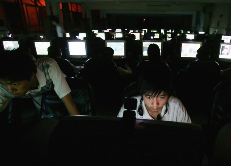 Một thanh niên ngồi trước một chiếc máy điện toán trong một quán cà phê internet. (Ảnh: Cancun Chu/Getty Images)