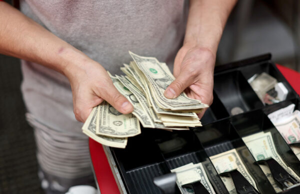 Ông Edwin Lopez sắp xếp tiền trong máy tính tiền tại Frankie's Pizza ở Miami hôm 12/01/2022. (Ảnh: Joe Raedle/Getty Images)