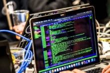 Một người đang chuyển một gói dữ liệu trên một chiếc máy điện toán khi đang làm việc trên máy điện toán xách tay ở Lille, Pháp, trong Diễn đàn An ninh mạng Quốc tế lần thứ 11 vào ngày 22/01/2019. (Ảnh: PHILIPPE HUGUEN/AFP/Getty Images)