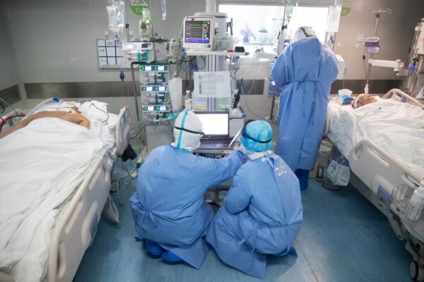 Nhân viên y tế điều trị cho bệnh nhân COVID tại một bệnh viện ở Vũ Hán, Trung Quốc vào ngày 19/03/2020. (Ảnh: STR/AFP qua Getty Images)
