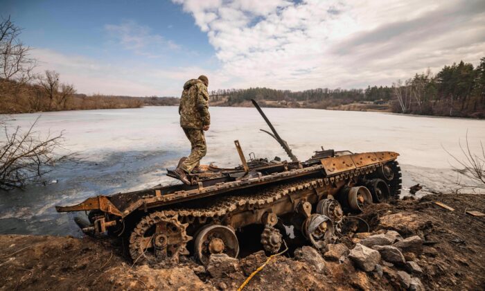 Một quân nhân Ukraine đứng trên một chiếc xe tăng Nga bị phá hủy ở thành phố Trostyanets thuộc phía đông bắc Ukraine sau khi Ukraine tuyên bố rằng họ đã tái chiếm thành phố này, một trong những nơi đầu tiên nằm dưới sự kiểm soát của Moscow, hôm 29/03/2022. (Ảnh: Fadel Senna/AFP qua Getty Images)