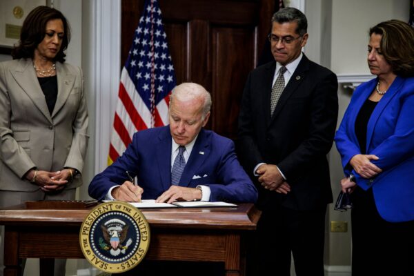 Tổng thống Joe Biden ký một sắc lệnh chỉ thị cho Bộ Y tế và Dịch vụ Nhân sinh (HHS) bảo đảm quyền phá thai trong khi Phó Tổng thống Kamala Harris, Bộ trưởng HHS Xavier Becerra và Phó Tổng chưởng lý Lisa Monaco đứng chứng kiến tại Tòa Bạch Ốc hôm 08/07/2022. (Ảnh: Samuel Corum, AFP/Getty Images)