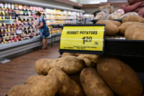 Một người mua hàng đi ngang qua tấm biển ghi giá mỗi pound khoai tây đỏ tại một siêu thị ở Montebello, California, hôm 23/08/2022. (Ảnh: Frederic J. Brown/AFP qua Getty Images)