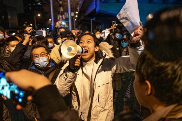 Một người biểu tình cầm một tờ giấy trắng và hô lớn khẩu hiệu trong cuộc biểu tình phản đối các biện pháp COVID-19 hà khắc ở Bắc Kinh hôm 28/11/2022. (Ảnh: Bloomberg qua Getty Images)