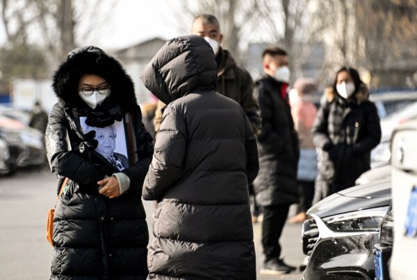 Một người phụ nữ cầm di ảnh của thân nhân tại một lò hỏa táng ở Bắc Kinh hôm 20/12/2022. (Ảnh: Noel Celis/AFP qua Getty Images)