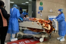Nhân viên y tế di chuyển một bệnh nhân COVID-19 trên băng ca cứu thương trong khu cấp cứu của Bệnh viện Trực thuộc Số 1 thuộc Đại học Y Trùng Khánh ở thành phố Trùng Khánh phía tây nam Trung Quốc hôm 22/12/2022. (Ảnh: Noel Celis/AFP qua Getty Images)