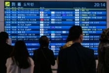 Hành khách chờ trước bảng hiển thị các chuyến bay quốc tế đến tại phi trường quốc tế Haneda của Tokyo hôm 28/12/2022. (Ảnh: Philip Fong/AFP qua Getty Images)