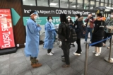 Các nhân viên y tế hướng dẫn các du khách đến từ Trung Quốc trước một trung tâm xét nghiệm COVID-19 tại Phi trường Quốc tế Incheon, phía tây Seoul hôm 03/01/2023. (Ảnh: Jung Yeon-je/AFP qua Getty Images)