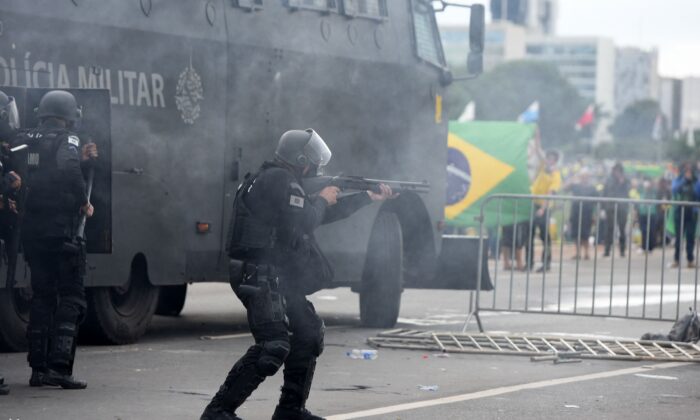 Lực lượng an ninh đối đầu với những người ủng hộ cựu Tổng thống Brazil Jair Bolsonaro tràn vào Dinh Tổng thống Planalto ở Brasilia hôm 08/01/2023. (Ảnh: Ton MOLINA/AFP via Getty Images)