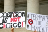 Mọi người giơ cao các tấm biểu ngữ trong một cuộc biểu tình ủng hộ một nhóm giáo viên chống lại việc thực thi quy định bắt buộc chích vaccine virus corona (COVID-19) cho nhân viên trường công lập tại Tòa án Liên bang Thurgood Marshall, ở thành phố New York, vào ngày 12/10/2021. (Ảnh: Michael M. Santiago/Getty Images)