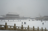 Du khách ghé thăm Tử Cấm Thành trong một trận tuyết rơi cuối mùa xuân ở Bắc Kinh, Trung Quốc hôm 18/03/2022. (Ảnh: Kevin Frayer/Getty Images)