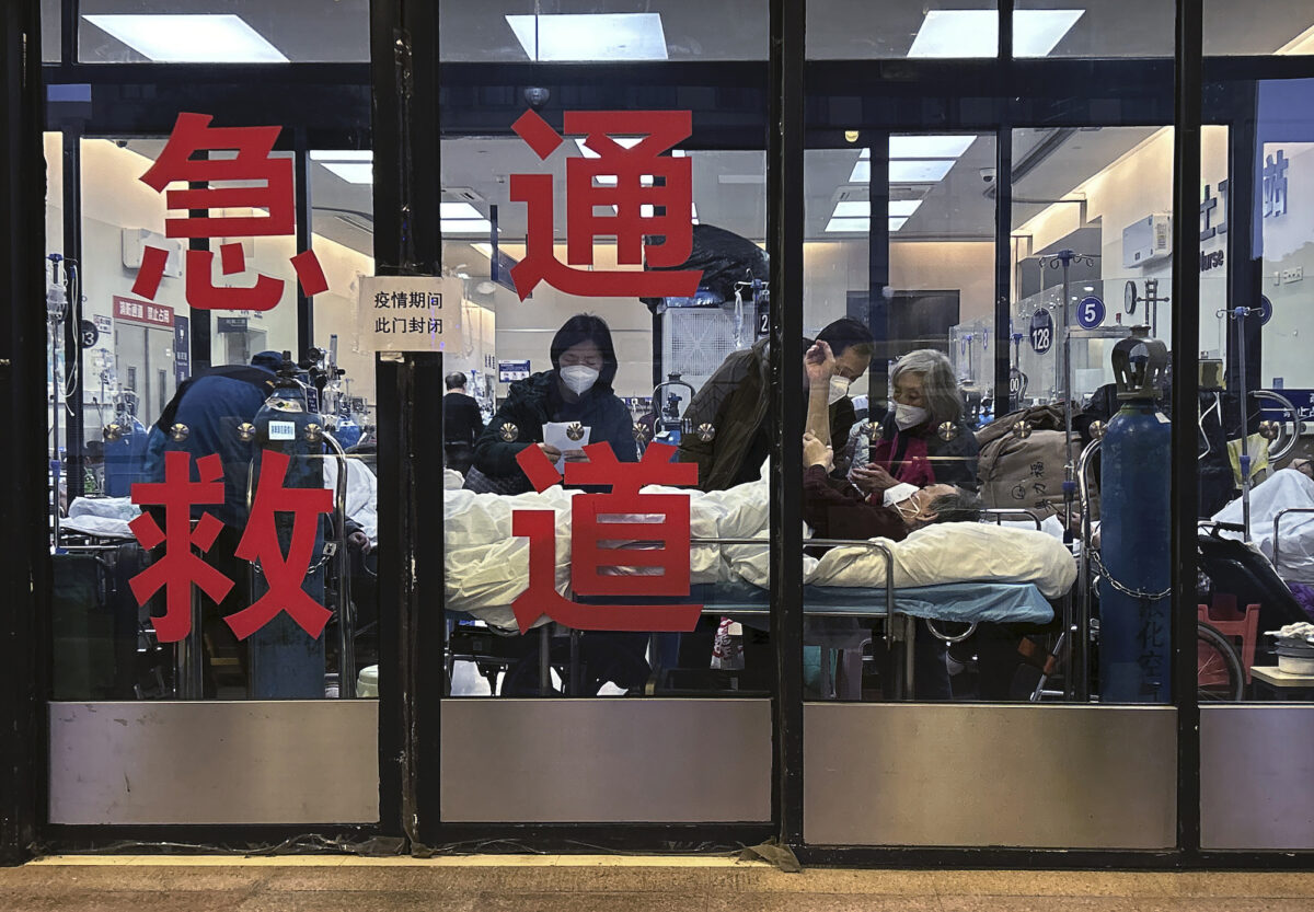 Bệnh nhân và những người chăm sóc được nhìn thấy ở lối vào đóng kín cửa của một phòng cấp cứu được sử dụng làm một khu vực bổ sung tại một bệnh viện ở Thượng Hải hôm 14/01/2023. (Ảnh: Kevin Frayer/Getty Images)