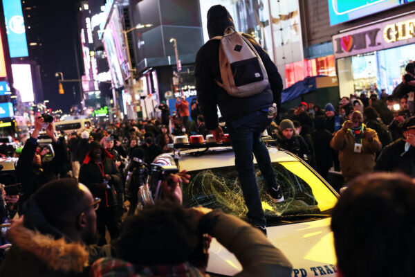 Một người biểu tình dẫm lên cửa kính một chiếc xe hơi của NYPD khi mọi người phản đối vụ sát hại anh Tyre Nichols ở Thành phố New York, hôm 27/01/2023. (Ảnh: Michael M. Santiago/Getty Images)
