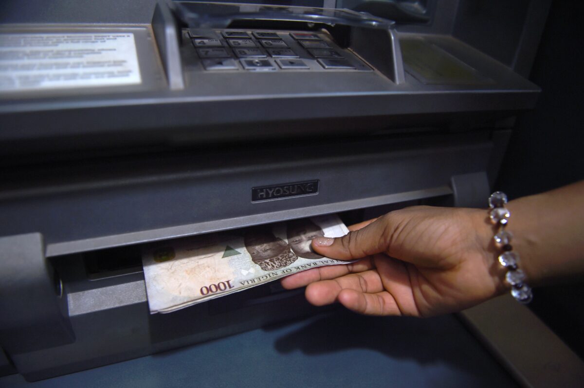 Một khách hàng rút đồng naira Nigeria từ máy rút tiền tự động (ATM) tại một ngân hàng ở Asaba, tiểu bang Delta, Nigeria, hôm 10/11/2016. (Ảnh: Pius Utomi Ekpei/AFP qua Getty Images)