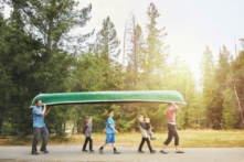 Một gia đình cùng nhau mang chiếc ca-nô của họ đến mép nước ở Hồ Jenny, GTNP, WY.