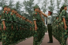 Một sĩ quan quân đội chỉnh lại mũ cho một sinh viên trong khóa huấn luyện quân sự tại Đại học Thanh Hoa ở Bắc Kinh ngày 07/09/2006. (Ảnh: China Photos/Getty Images)