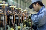 Một công nhân Trung Quốc sửa những chiếc máy nén dọc theo một dây chuyền sản xuất máy điều hòa không khí tại Công ty Thiết bị Điện gia dụng Hitachi của Nhật Bản ở Thượng Hải, tháng 03/2003. (Ảnh: Liu Jin/AFP/Getty Images)
