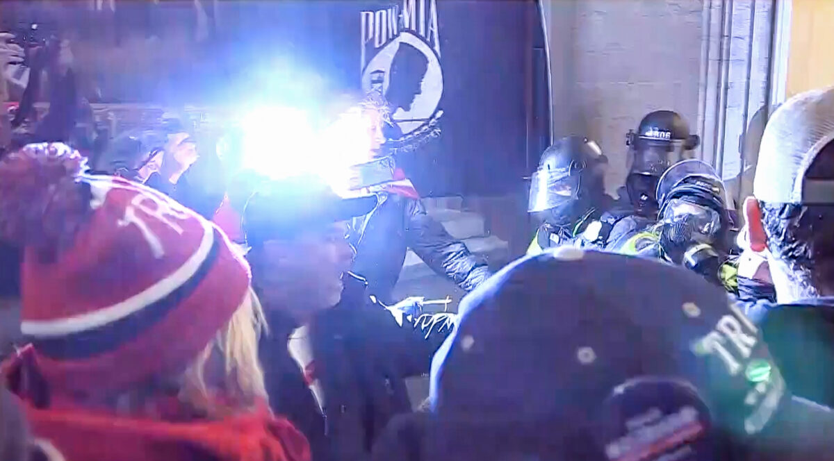 Một pha đèn flash máy ảnh chiếu sáng một cuộc đối đầu giữa những người biểu tình và cảnh sát ở Điện Capitol Hoa Kỳ vào ngày 06/01/2021. (Ảnh: Bộ Tư pháp Hoa Kỳ/Ảnh chụp màn hình qua The Epoch Times)