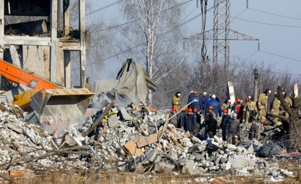 Các nhân viên và thành viên thuộc Bộ Tình trạng khẩn cấp dọn dẹp các mảnh vỡ từ một tòa nhà bị hư hại được dùng làm nơi ở tạm thời cho binh lính Nga, 63 người trong số họ đã thiệt mạng trong một cuộc tấn công bằng hỏa tiễn của Ukraine hôm 03/01/2023. (Ảnh: Alexander Ermochenko/Reuters)