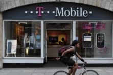 Một người đàn ông đạp xe qua cửa hàng T-Mobile ở Phố Fleet, London, Anh. Hôm Chủ nhật (15/01) AT&T Inc. đã đồng ý mua nhà mạng vô tuyến T-Mobile, trong một thỏa thuận trị giá 39 tỷ USD bằng tiền mặt và cổ phiếu. (Ảnh: Carl Court/AFP/Getty Images)