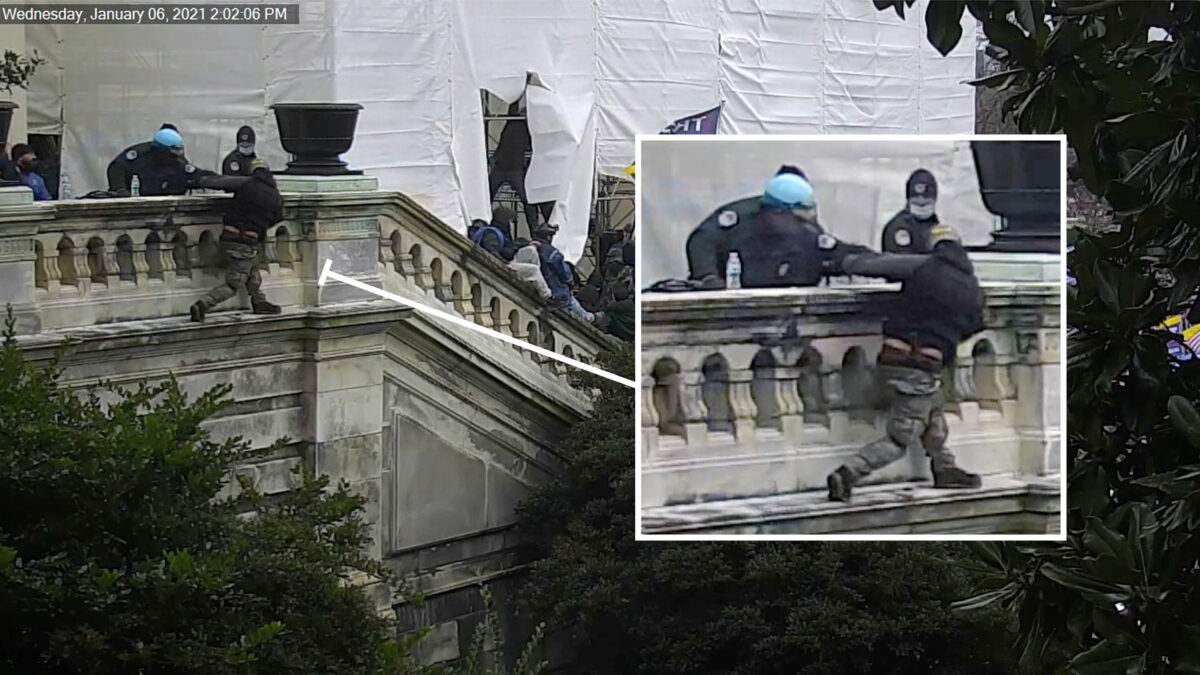 Một sĩ quan cảnh sát đẩy người biểu tình Derrick Vargo ra khỏi lan can cầu thang tại Điện Capitol Hoa Kỳ vào ngày 06/01/2021. (Ảnh: Cảnh sát Điện Capitol Hoa Kỳ/Ảnh chụp màn hình qua The Epoch Times)