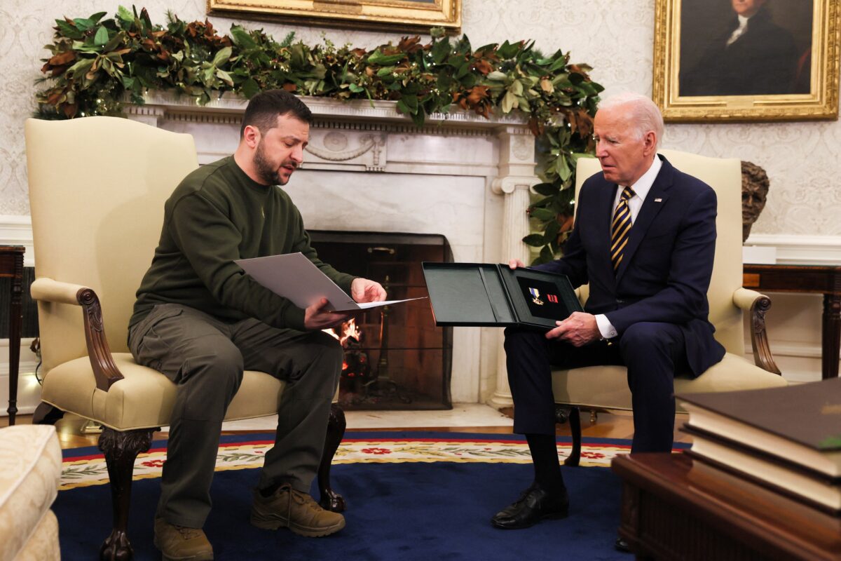 Tổng thống Ukraine Volodymyr Zelensky (trái) chuyển quà của một người lính cho Tổng thống Hoa Kỳ Joe Biden tại Oval Office ở Tòa Bạch Ốc vào ngày 21/12/2022. (Ảnh: Leah Millis/Reuters)