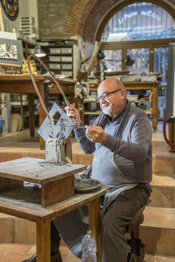 Ông Renzo Scarpelli sử dụng một chiếc cưa vòng cung truyền thống để cắt những mẫu đá khảm. (Ảnh: Guido Cozzi)