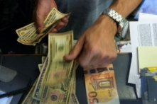 Một nhân viên thu ngân đổi một tờ 50 Euro sang USD tại một quầy đổi tiền ở Rome, Ý, hôm 13/07/2022. (Ảnh: Gregorio Borgia/AP)