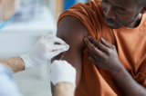 Một y tá chích vaccine vào vai một người đàn ông Mỹ gốc Phi Châu. (Ảnh: Shutterstock)