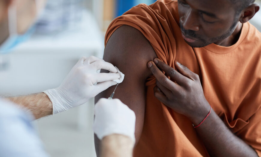 Một y tá chích vaccine vào vai một người đàn ông Mỹ gốc Phi Châu. (Ảnh: Shutterstock)