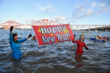 Người dân Anh chào đón năm mới bằng cách ngâm mình trong làn nước biển lạnh giá và giương biểu ngữ “Chúc mừng năm mới”. Ảnh chụp tại tại Firth of Forth vào ngày 01/01/2017. (Ảnh: Jeff J Mitchell/Getty Images)