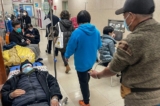 Các bệnh nhân nằm trên băng ca ngoài hành lang của khu vực cấp cứu tại Bệnh viện Hoa Sơn, Thượng Hải hôm 09/01/2023. (Ảnh: Hector Retamal/AFP/Getty Images)