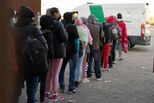Những người nhập cư bất hợp pháp xin tị nạn xếp hàng để được các nhân viên Hải quan và Biên phòng Hoa Kỳ giải quyết cho họ tại một hàng rào biên giới Hoa Kỳ-Mexico gần San Luis, Arizona, hôm 26/12/2022. (Ảnh: Rebecca Noble/AFP qua Getty Images)